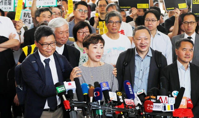 Pro-democracy activist Chan Kin-man pats fellow activist Tanya Chan's shoulders as she speaks to the media before a verdict on their involvement in the Occupy Central, also known as "Umbrella Movement", in Hong Kong, China April 9, 2019. (REUTERS)