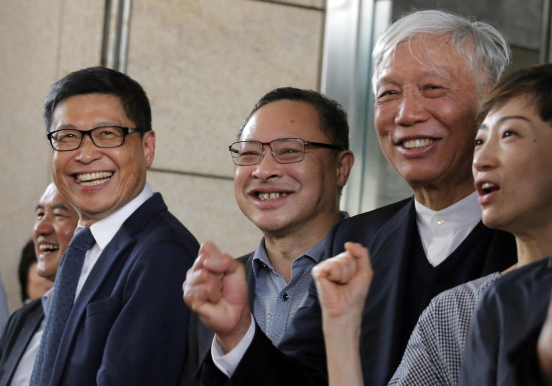 From right: Occupy Central leaders Tanya Chan, Chu Yiu-ming, Benny Tai and Chan Kin-man shout slogan as they are released on bail at a court in Hong Kong on Tuesday, April 9, 2019. (AP)