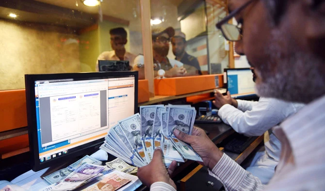 A Pakistani currency dealer counts USD banknotes at a currency exchange shop in Karachi on Aug. 1, 2018. (AFP)