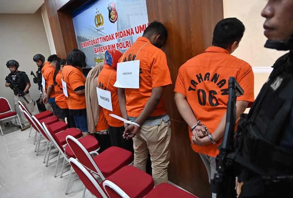 Suspects face the wall during a press conference by Indonesian officials in Jakarta, on April 9, 2019, about trafficking-related of fences. (AFP)