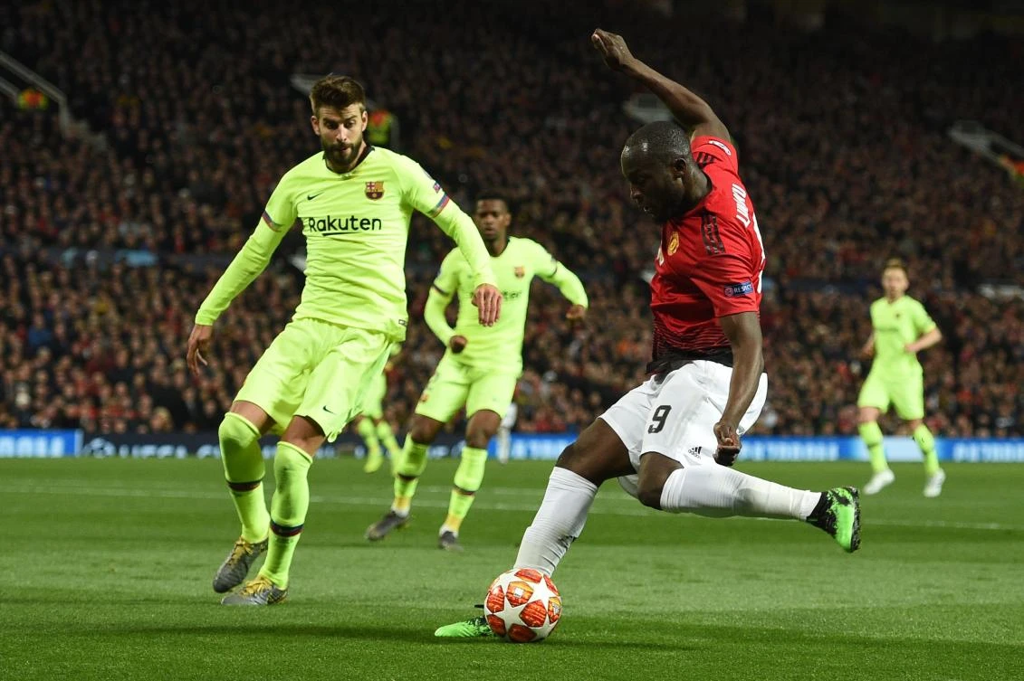 Manchester United's Belgian forward Romelu Lukaku (R) has a shot by Barcelona's Spanish defender Gerard Pique during the UEFA Champions League first leg quarterfinal football match between Manchester United and Barcelona at Old Trafford. (AFP)