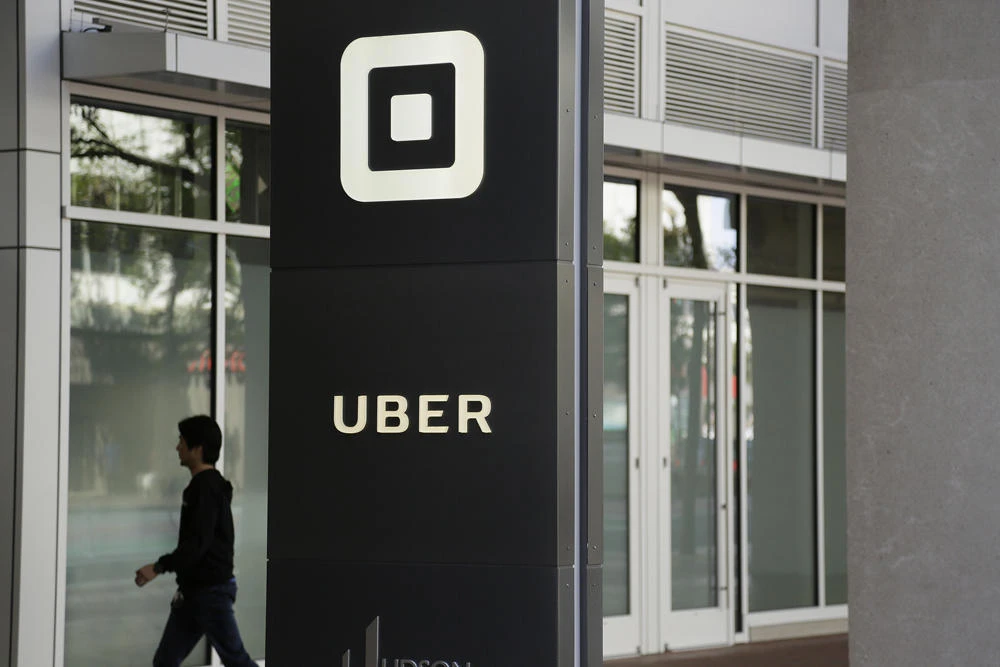 In this June 21, 2017, file photo a man walks into the building that houses the headquarters of Uber in San Francisco. Documents released on April 11, 2019, offered the most detailed view of the world's largest ride-hailing service since its inception a decade ago. (AP Photo/Eric Risberg, File)