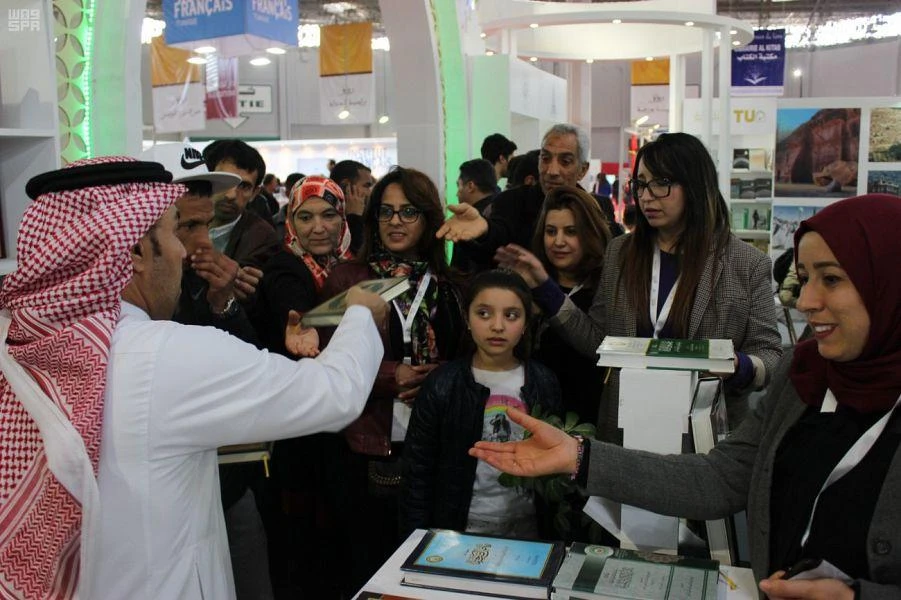 A representative of Saudi Arabia's King Fahd Complex for the Printing of the Holy Qur’an distribute copies of the Holy Qur’an to participants of the 35th Tunis International Book Fair in Tunisia on April 11, 2019. (SPA)