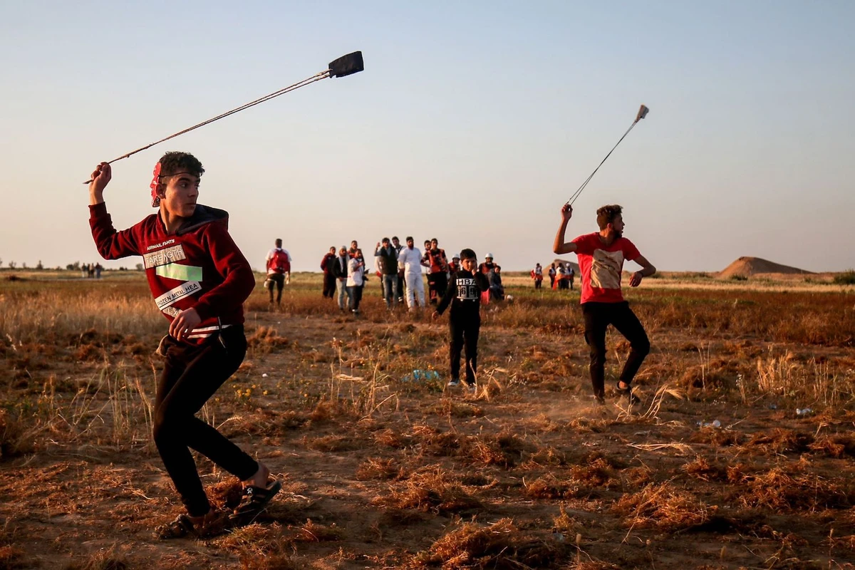 A Palestinian uses a slingshot during a demonstration near the border with Israel, east of Khan Yunis in the southern Gaza Strip, on April 12, 2019. (AFP)