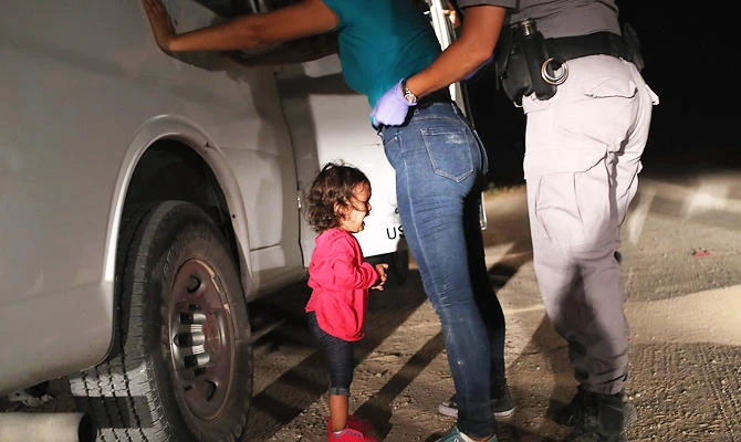 In this file photo taken on June 12, 2018 a two-year-old Honduran asylum seeker cries as her mother is searched and detained near the US-Mexico border in McAllen, Texas. (AFP)