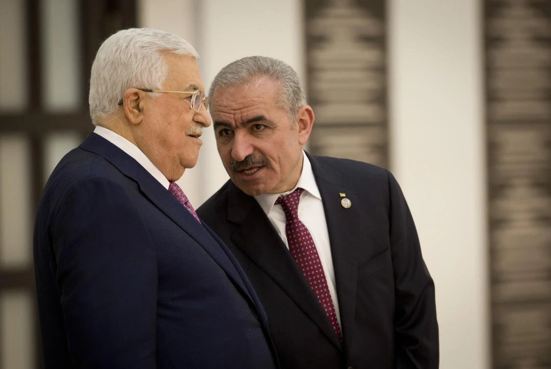 Palestinian Prime Minister Mohammad Ishtayeh, right, talks with Palestinian President Mahmoud Abbas during a swearing in of the new government in the West Bank city of Ramallah. (AP)