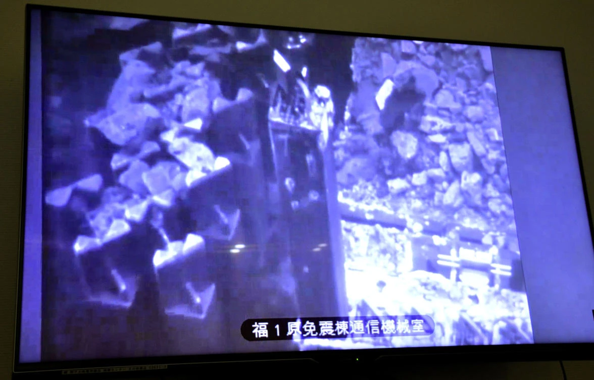 A screen shows the removal of first of 566 used and unused fuel units stored in the pool at Unit 3 at Fukushima Dai-ichi nuclear plant, on April 15, 2019. (Kyodo News via AP)