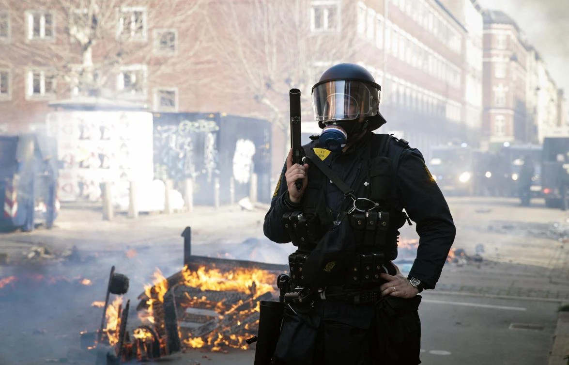 Danish police officer stands guard during a conflict at Norrebro in Copenhagen after a demonstration in the area on April 14, 2019. (AFP)