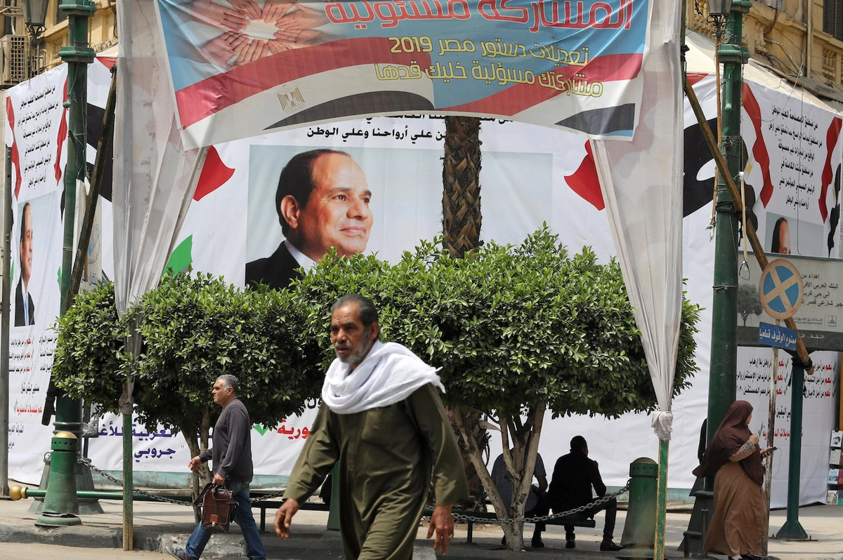 Pedestrians walk in front of a banner of the Egyptian President Abdel Fattah al-Sisi before the upcoming referendum on constitutional amendments in Cairo. (Reuters)