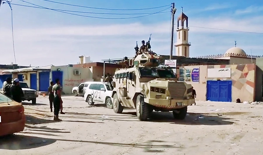A video grab shows fighters riding atop an armored vehicle in Tripoli on Tuesday. (AFP)