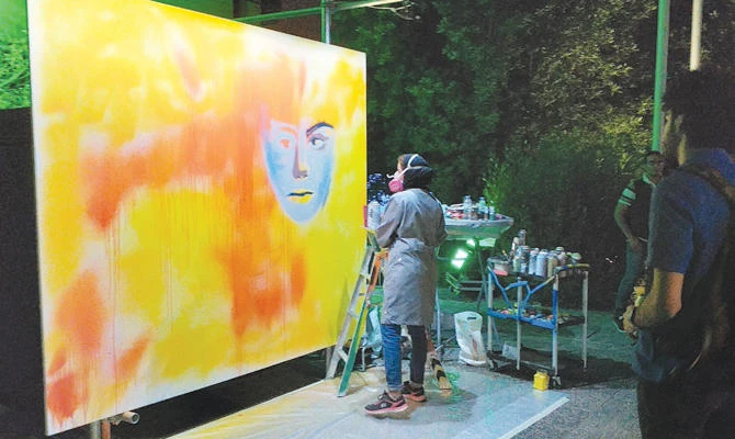 Noura bin Saidan, a top graffiti artist, performs live art at the festival. The event aims to boost the Saudi entertainment sector. (AN photo)