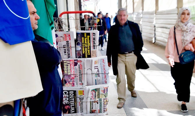 Algerians walk past newspapers reading "Bouteflika leaves" the day after Algeria's veteran President Abdelaziz Bouteflika informed the Constitutional Council that he was resigning, in Algiers on April 3, 2019. (AFP)
