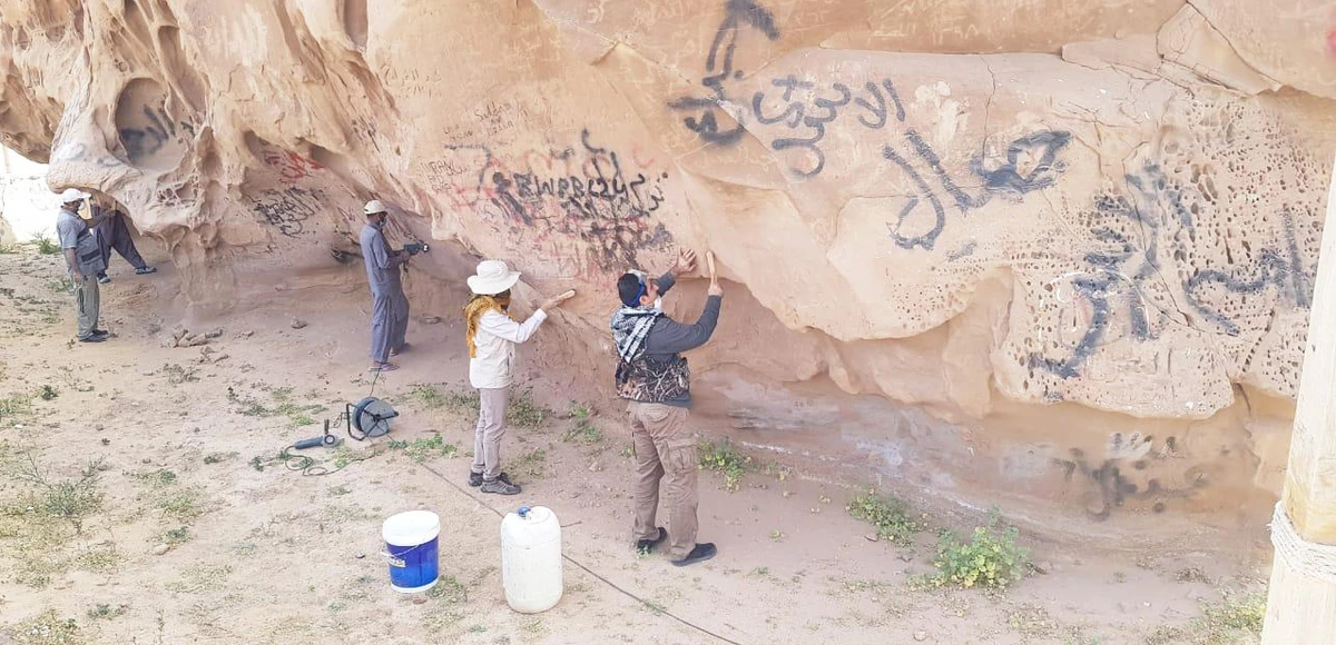A team from the Saudi Commission on National Heritage and Tourism work to restore the "Antara's Rock" to its original form. (SPA)