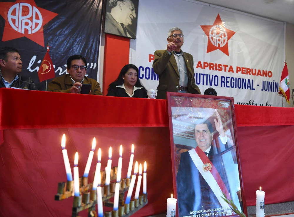 Supporters of Peruvian ex-president Alan Garcia participate in a memorial service at the American Popular Revolutionary Alliance (APRA) party headquarter’s in the Andean city of Huancayo, 350 kilometers east of Lima after learning that he died on April 17, 2019 after shooting himself in the head. (AFP / CRIS BOURONCLE)