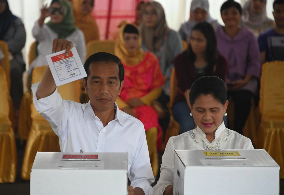 President Joko Widodo, left, and his spouse Iriana cast their ballot at a polling center in Jakarta on Wednesday, April 17, 2019. (AFP)