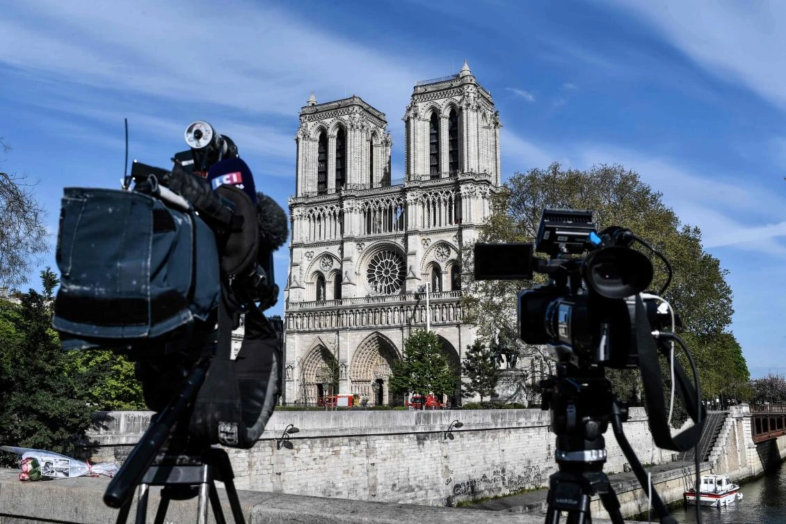 Journalists cameras point at the Notre Dame de Paris Cathedrale on April 17, 2019 in central Pairs, two days after a fire engulfed the 850-year-old gothic masterpiece, destroying the roof and causing the steeple to collapse. (AFP)