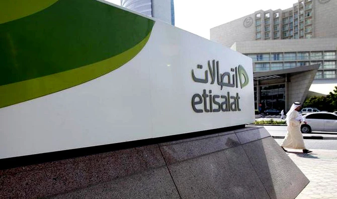 In this file photo, a man walks past a sign at the headquarters of telecommunications company Etisalat in Dubai. (Reuters)
