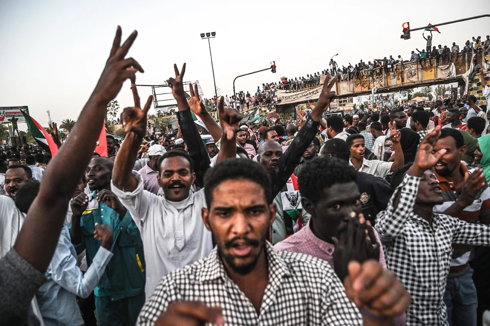 Sudanese protestors shout slogans as they flash victory signs during a protest outside the army complex in the capital Khartoum on April 20, 2019. (AFP / OZAN KOSE)