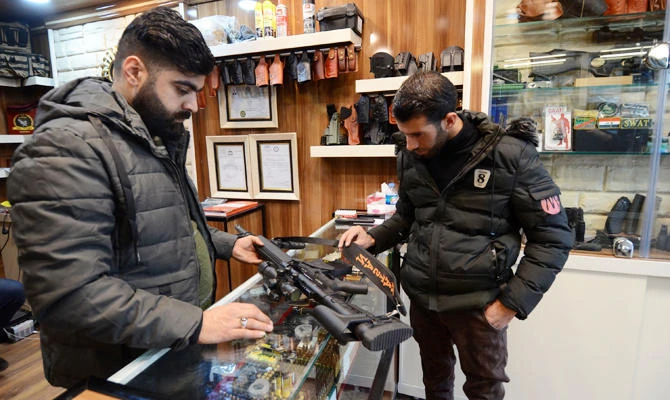 A customer inspects a rifle sold in a gun shop in the northern Iraqi city of Mosul on January 28, 2019. (AFP)