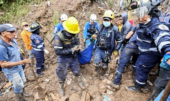 Rescue workers carry a corpse after a landslide in Rosas, Valle del Cauca department, in southwestern Colombia, on April 21, 2019. (AFP)