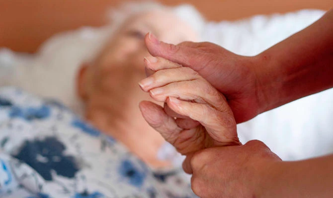 Slovakian care taker Alena Konecna helps a 89-year-old bedridden woman in Leoben, Austria on March 20, 2019. (AFP)