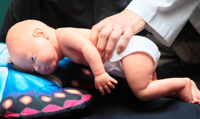 In this March 22, 2012 file photo, a doctor demonstrates how an infant can die due to unsafe sleeping practices using a scene re-enactment doll in Norfolk, Va. (AP)