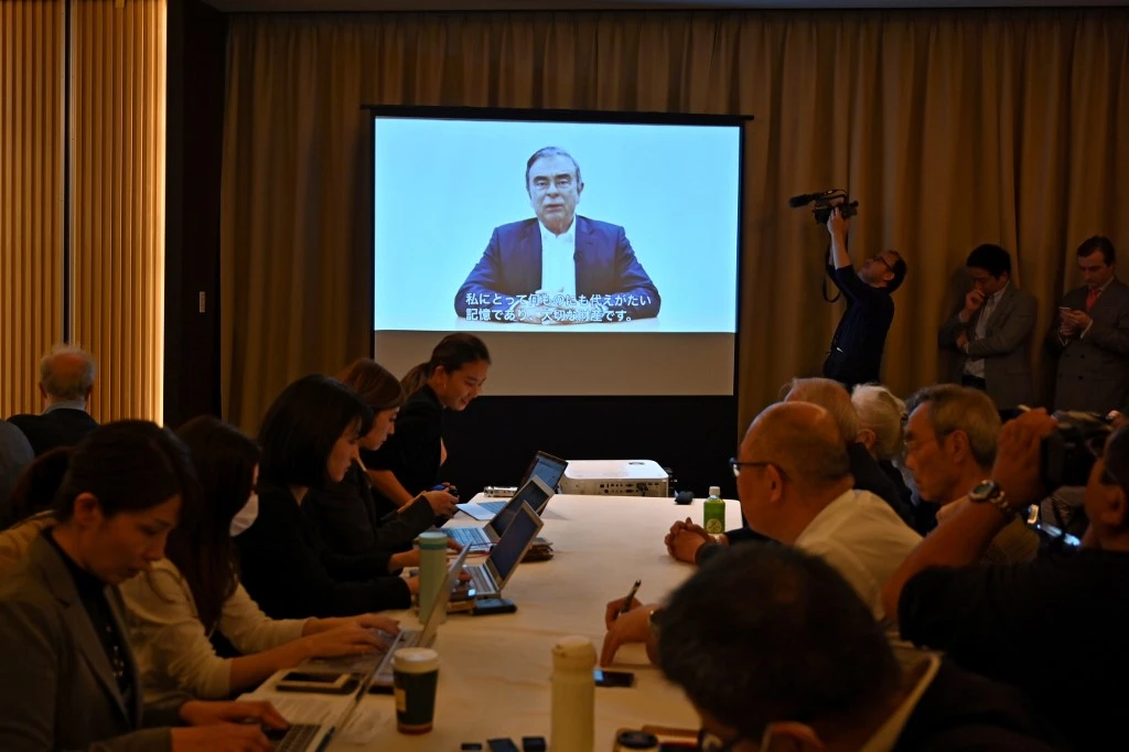 Journalists look on as a recorded Carlos Ghosn video message plays during a press conference on April 9, 2019, before his most recent re-arrest. (AFP)