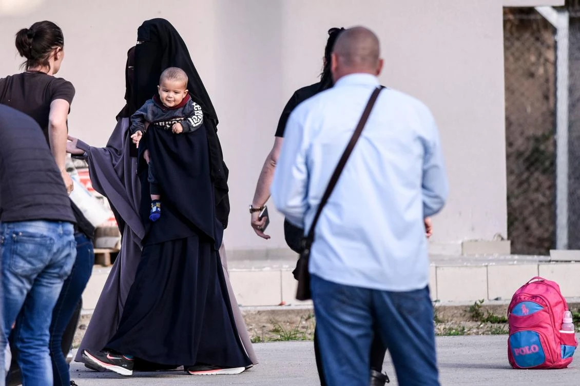 A Kosovar woman and a child returned from Syria leave the foreign detention center as they reunite with their family members in the village of Vranidoll. (AFP)