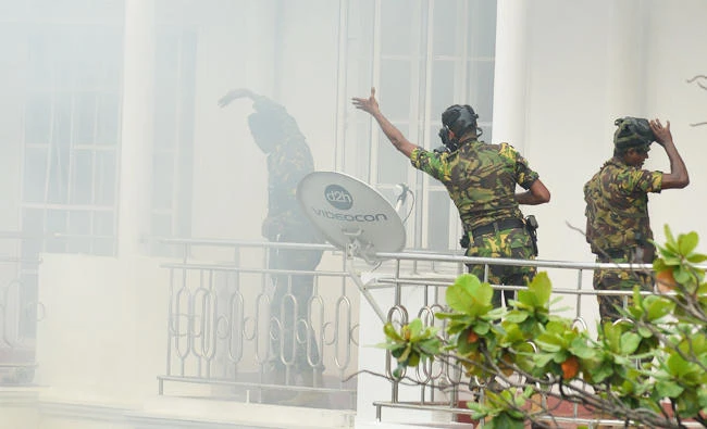Sri Lankan Special Task Force (STF) personnel gesture outside a house during a raid -- after a suicide blast had killed police searching the property -- in the Orugodawatta area of the capital Colombo on April 21, 2019, following a series of blasts in churches and hotels. (AFP)