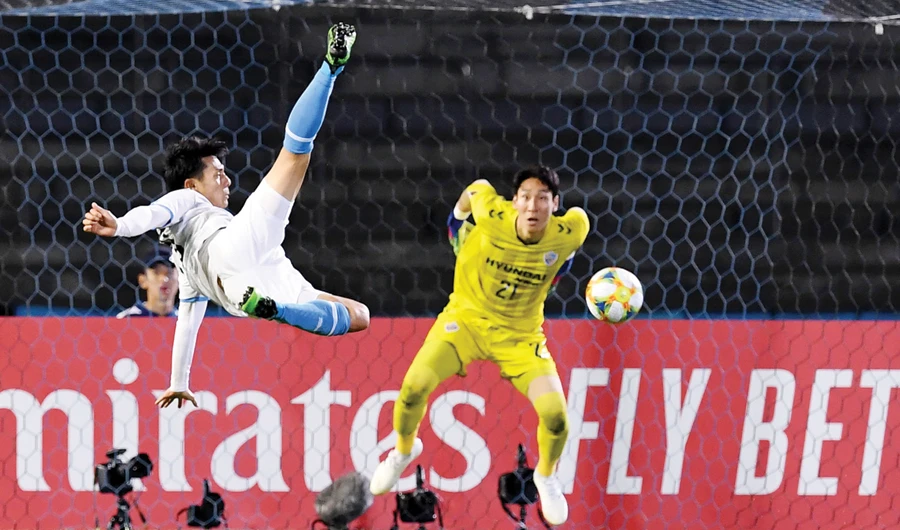 Kawasaki forward Kei Chinen, left, shows a bicycle kick to Ulsan's goalkeeper Oh Seung-Hoon during their AFC Champions League match on Tuesday. (AFP)