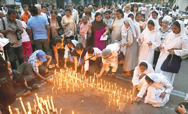 Catholic nuns and others light candles during a prayer meeting in Kolkata for victims of Sunday's bombings in Sri Lanka on Tuesday. (AP)