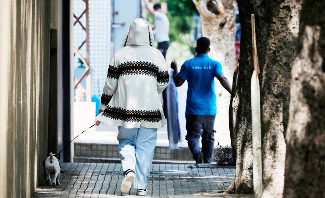 An Asian domestic worker walks her employer's dog in the Lebanese capital of Beirut, on April 23, 2019. (AFP)
