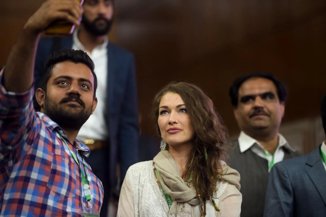 A Pakistani man takes a selfie photo with Canadian ‘social media influencer’ Rosie Gabrielle, center, as she attends the Pakistan Tourism Summit in Islamabad. (AFP)