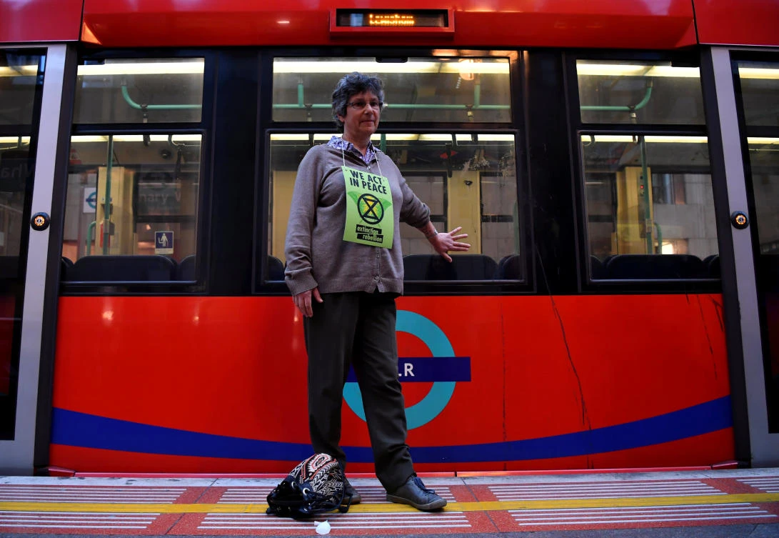 A protester glues her hand to a train during the Extinction Rebellion protest in London on April 25, 2019. (Reuters)