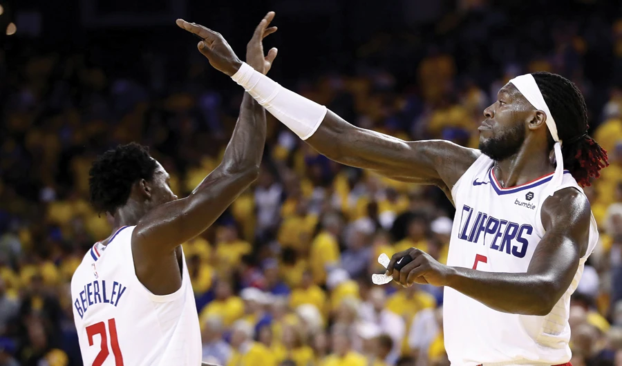 Montrezl Harrell (No. 5) high-fives Patrick Beverley of the LA Clippers during their game against the Golden State Warriors on Wednesday. (AFP)