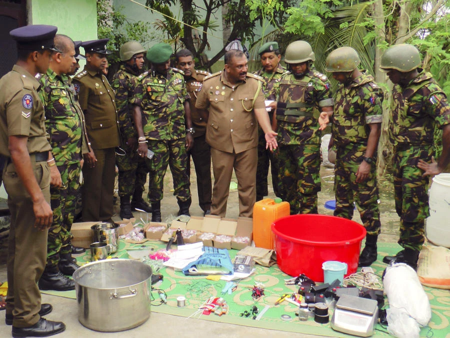 Sri Lankan police and army officers display bomb making materials recovered from a hideout of militants after Friday's gunbattle in Kalmunai, in eastern Sri Lanka, on April 27, 2019. (AP Photo/Achala Upendra)