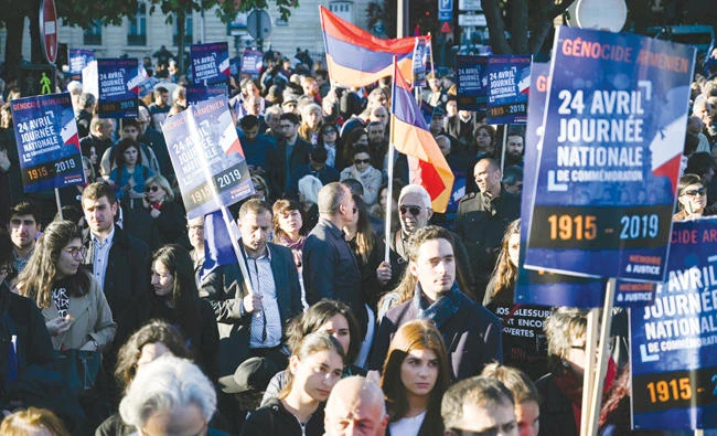 People hold placards as they gather Place du Canada in Paris, on Wednesday, marking the anniversary of the Armenian genocide. (AFP)