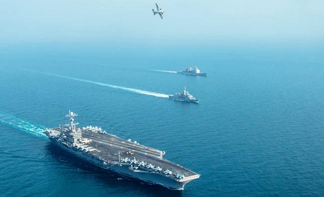This US Navy photo obtained January 21, 2019 shows the aircraft carrier USS John C. Stennis (CVN 74)(L) the Royal Australian Navy frigate HMAS Ballarat (FFH 155), and the guided-missile cruiser USS Mobile Bay (CG 53(R), sailing in formation as a C-2A Greyhound, assigned to Fleet Logistics Combat Support Squadron (VRC) 30, detachment 4, conducts a flyover in the Gulf, January 16, 2019, during exercise Intrepid Sentinel. (AFP)