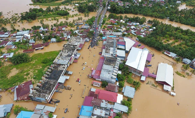 TOPSHOT - This aerial picture taken on April 27, 2019 shows a general view of submerged buildings after heavy rain caused flooding in Bengkulu on the Indonesian island of Sumatra. At least 10 people are dead and eight are missing after days of heavy rain-triggered floods and landslides on the Indonesian island of Sumatra, authorities said on April 28. / AFP / DIVA MARHA