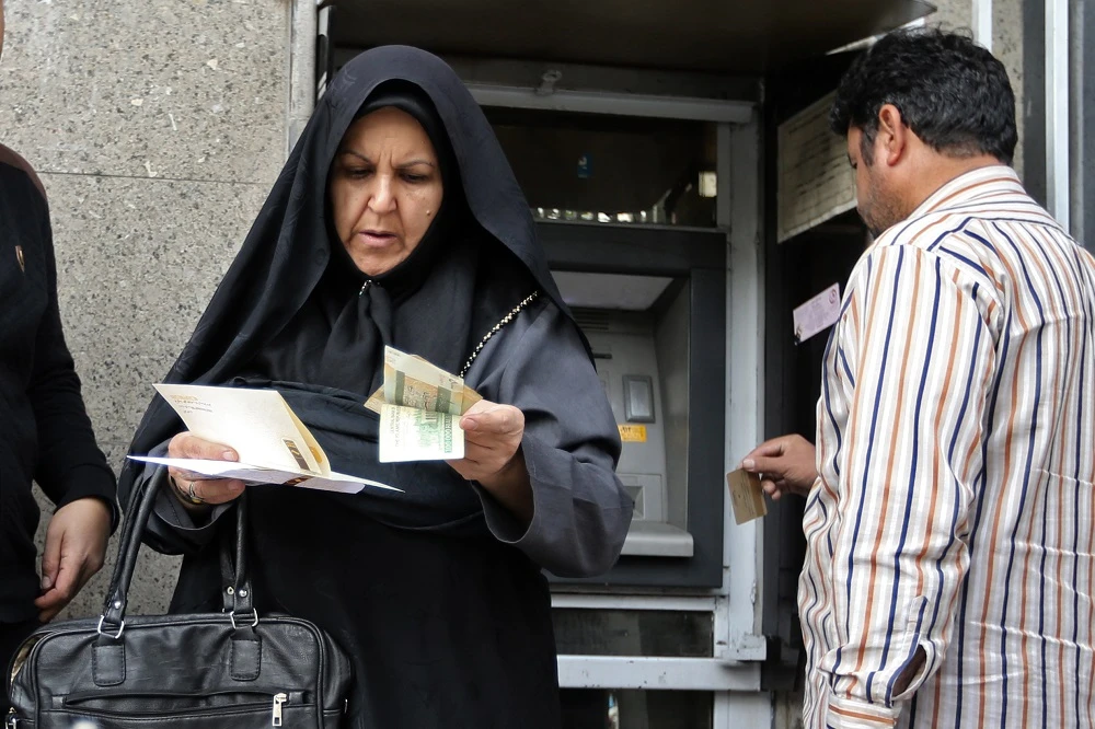 People withraw money from an automated teller machine in the Iranian capital Tehran's grand bazar on November 3, 2018. (File/AFP)
