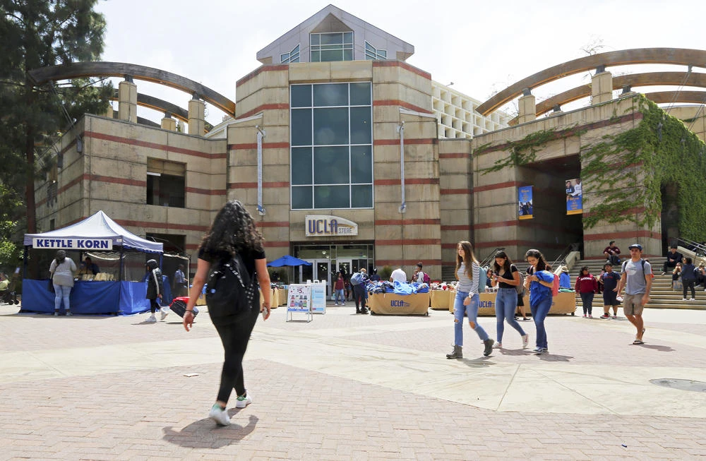 Students are seen at the campus of the University of California, Los Angeles on April 26, 2019. American college students are turning to a new funding strategy, pledging a share of their future earnings to pay for their education rather than borrowing. (AP Photo/Reed Saxon)