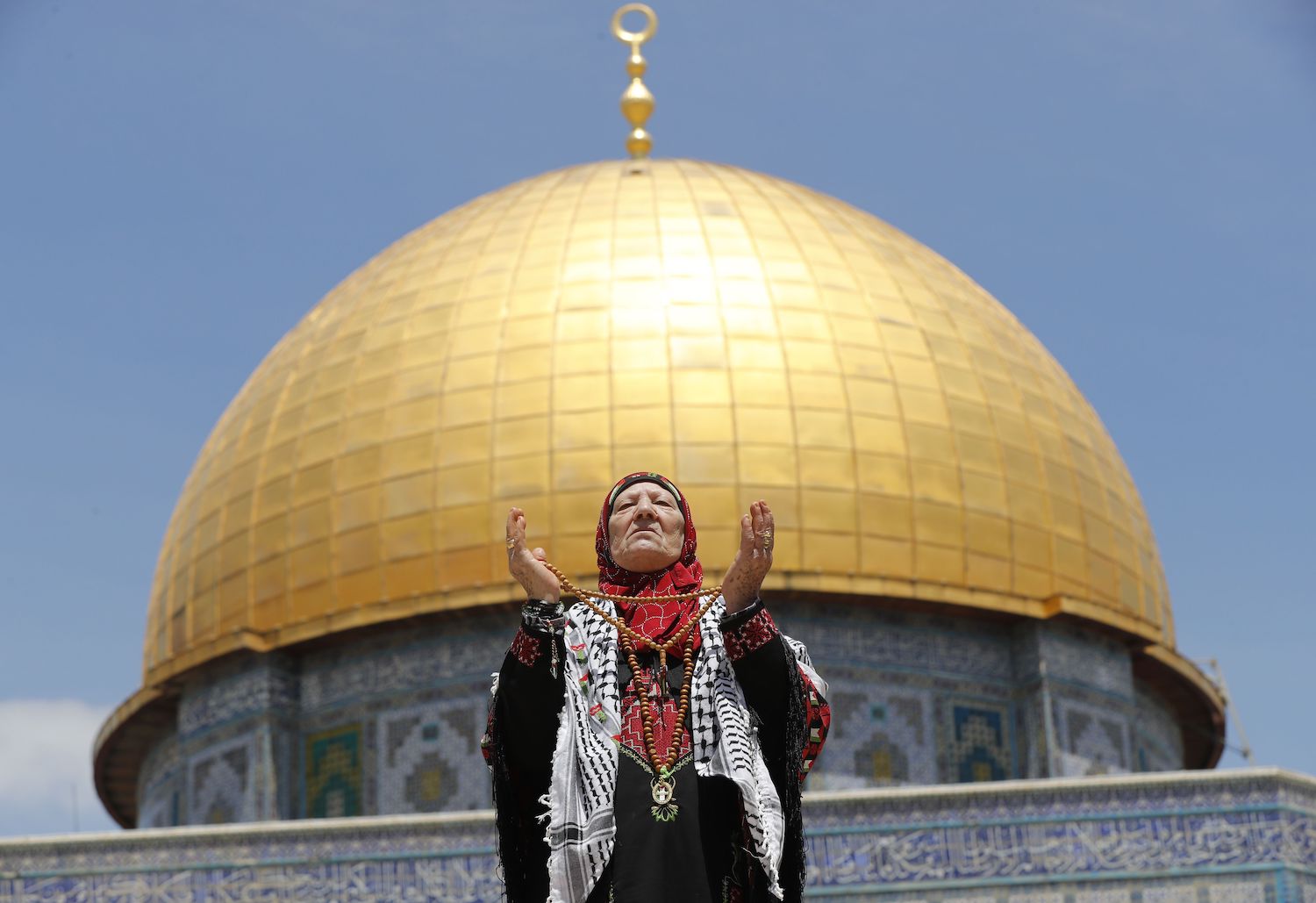 A Palestinian Muslim woman prays in front of the Dome of the Rock mosque in the Al-Aqsa Mosque compound in Jerusalem on May 10, 2019 on the first Friday prayers of the holy fasting month of Ramadan. (AFP)