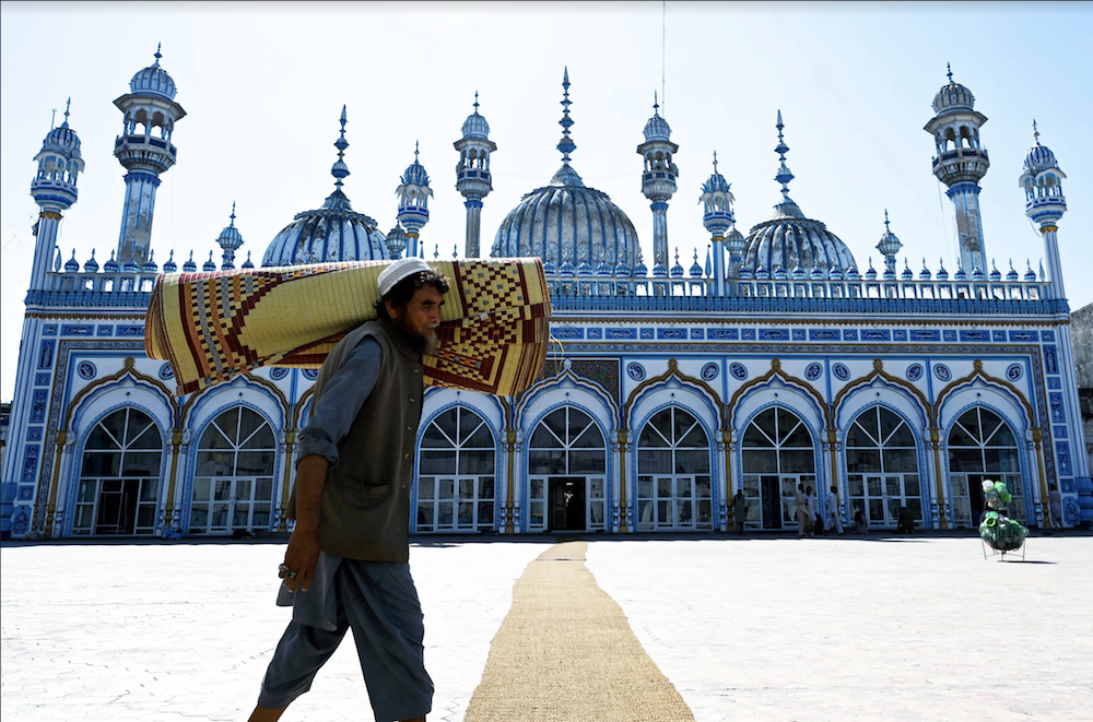 A Pakistani Muslim carries a prayer mat rolled up on his shoulder in preparation for the night special prayers in Rawalpindi on May 6, 2019, ahead of the start of the holy fasting month of Ramadan.  (AFP)