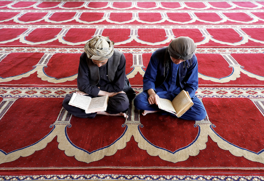 Afghan men read the Koran at a mosque during the holy month of Ramadan in Kabul, Afghanistan May 7, 2019. (Reuters)