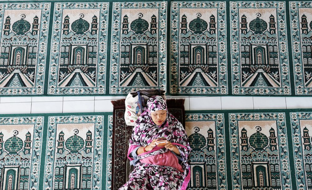 A woman rests at a mosque during the first day of the holy fasting month of Ramadan Monday, May 6, 2019, in Bali, Indonesia. (AP)