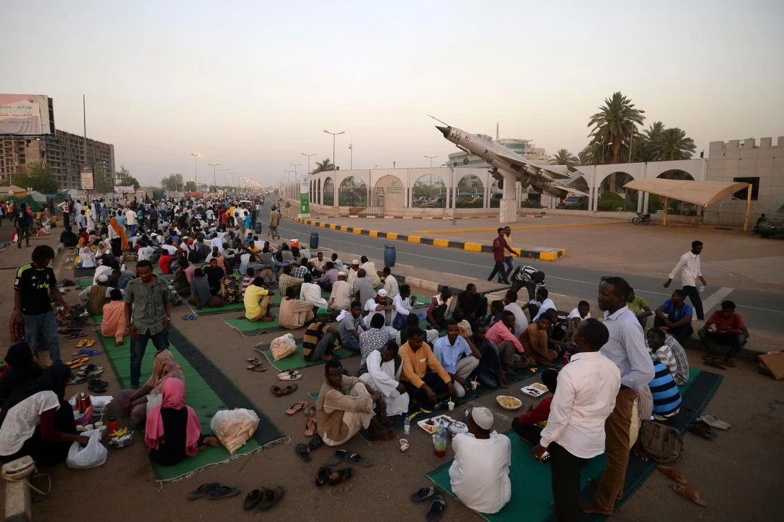 Sudanese protesters gather to break their fast outside the army headquarters in Khartoum on May 7, 2019, on the second day of the holy Muslim month of Ramadan. Demonstrators remain camped out in the soaring heat of Khartoum calling for civilian rule three weeks after the military ousted veteran leader Omar al-Bashir. Sudan has been rocked by months of nationwide protests that initially targeted Bashir's 30-year rule, accusing the leader and his regime of running the country's economy into the ground. / AFP / MOHAMED EL-SHAHED