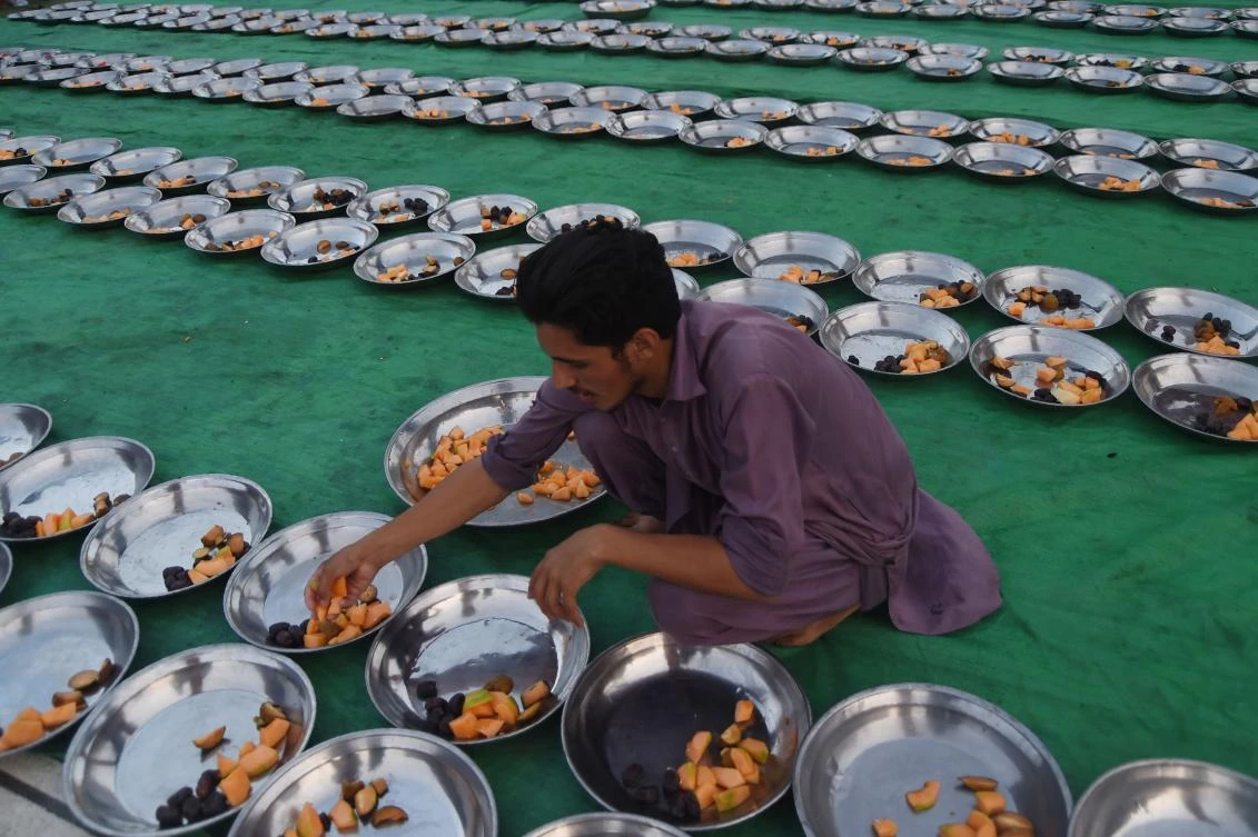 A Pakistani volunteer prepares Iftar food for Muslim devotees prior to breaking their fast on the first day of the holy month of Ramadan at a mosque in Karachi on May 7, 2019. Muslims throughout the world are marking the month of Ramadan, the holiest month in the Islamic calendar during which Muslims fast from dawn until dusk. / AFP / ASIF HASSAN