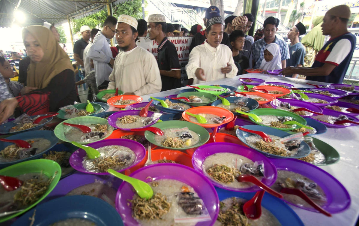 Indonesian Muslims collect food provided by Al Mashun Great Mosque for free to break their fast, at the end of the second day the holy fasting month of Ramadan in Medan, North Sumatra, Indonesia, Tuesday, May 7, 2019. Muslims around the world are observing Ramadan, the holiest month in Islamic calendar, where they refrain from eating, drinking, smoking, and sex from dawn to dusk. (AP Photo/Binsar Bakkara)