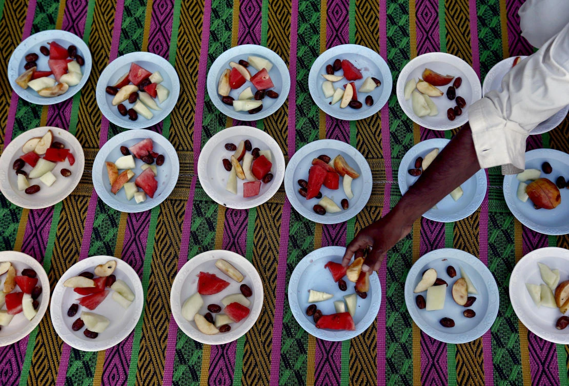 A volunteer arranges food for the "Iftar" meal for Muslims to break their fast at sundown, during the fasting month of Ramadan at a free food distribution point in Islamabad, Pakistan, Tuesday, May 7, 2019. Muslims around the world are observing Ramadan, the holiest month in Islamic calendar. (AP Photo/Anjum Naveed)