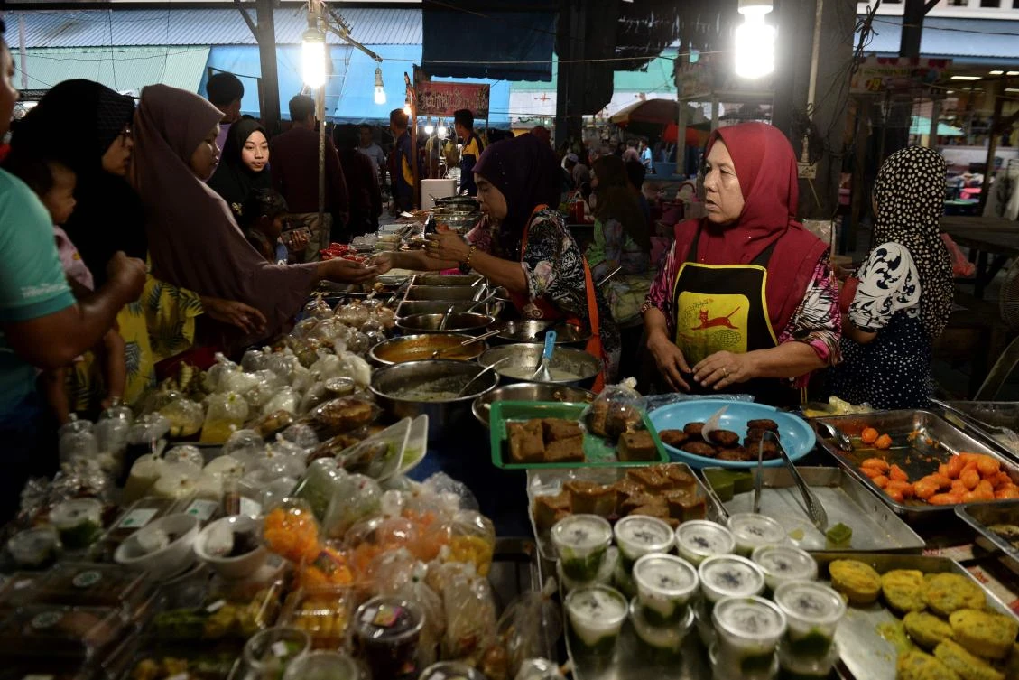 Thai Muslims buy food items at a market prior to breaking their fast during the holy month of Ramadan in Narathiwat on May 7, 2019. Muslims around the world abstain from eating, drinking and conducting sexual relations from sunrise to sunset during Ramadan, the holiest month in the Islamic calendar. / AFP / Madaree TOHLALA